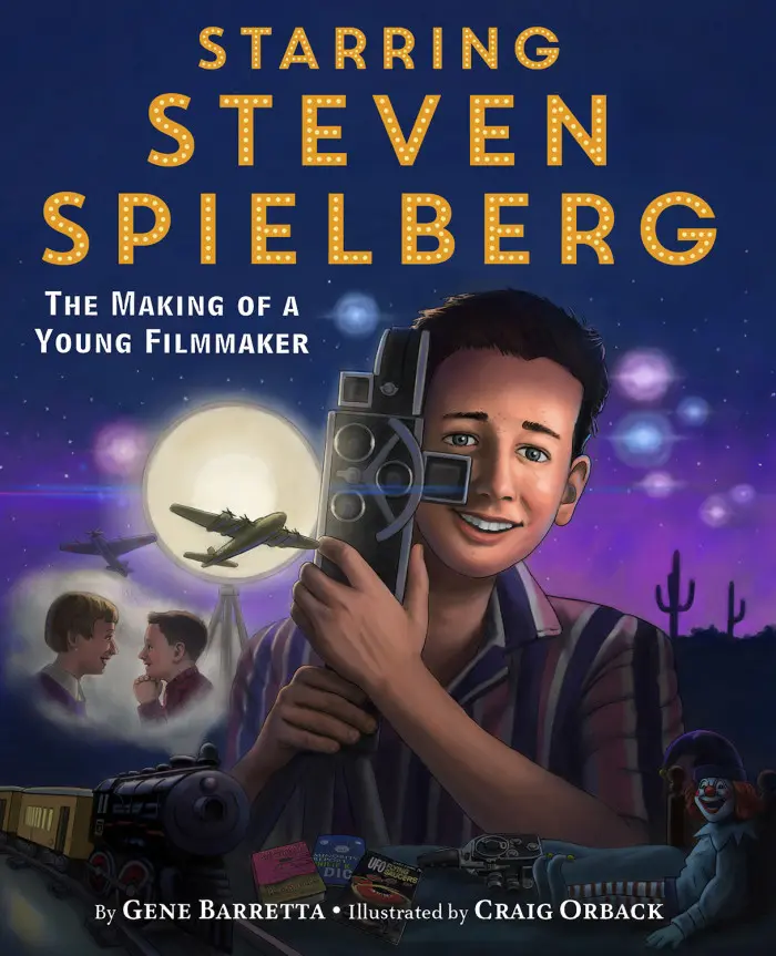 Boy holding vintage movie camera at night